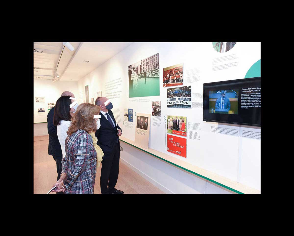Asistentes observando las fotografías de la exposición.