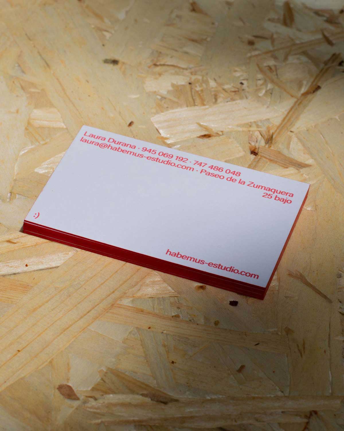 Taco pequeño de tarjetas con el canto rojo encima de una mesa de madera.