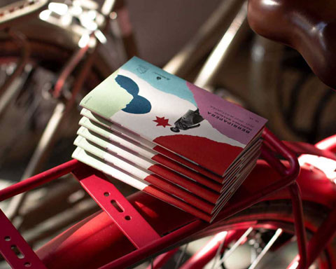 Berripaperas apiladas sobre la rejilla de una bicicleta roja.