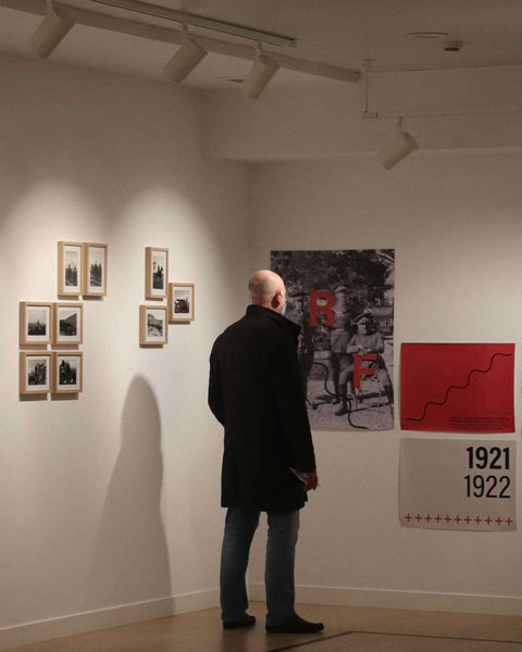 Asistente observando un poster de la exposición.