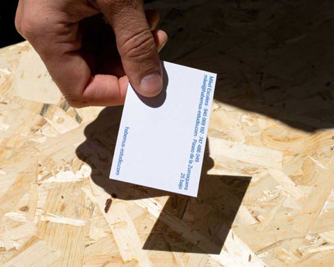 Mano de Mikel dejando una de sus tarjetas sobre la mesa.